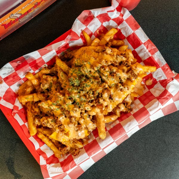 Romeo's Vegan Burgers' loaded fries with vegan cheese sauce, crumbled vegan meat, and parsley.